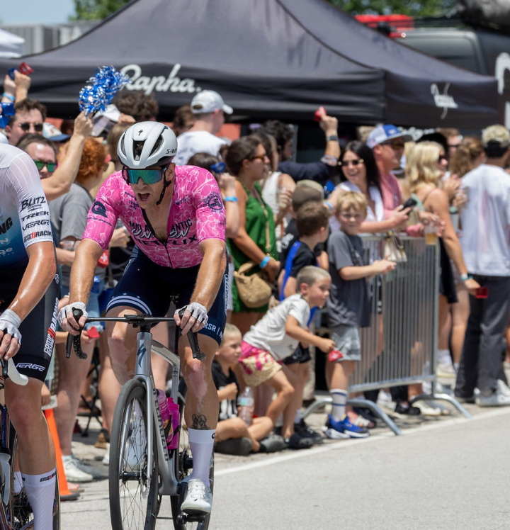 Rider racing past a cheering crowd